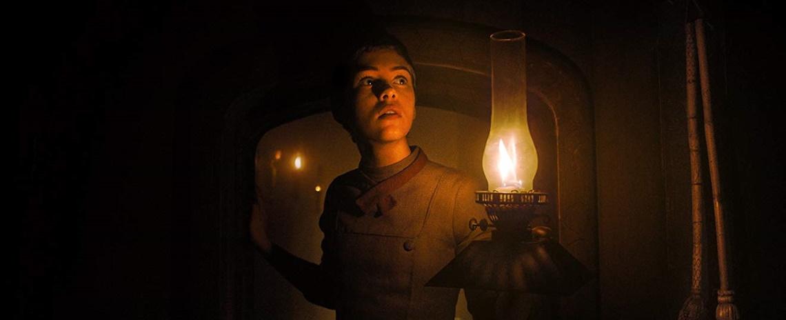 Gretel (Sophia Lillis) investigates the witch's house by lamplight in Osgood Perkins' 'Gretel & Hansel'.